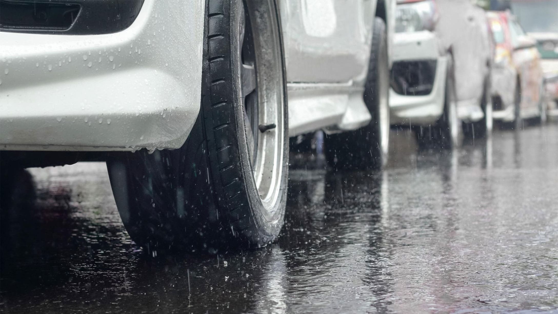 Llanta delantera de auto blanco bajo la lluvia